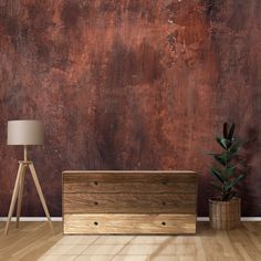 an empty room with a wooden chest next to it and a lamp on the floor