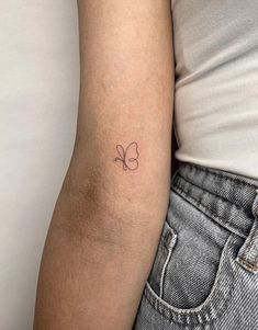 a woman's arm with a small clover tattoo on the left side of her arm