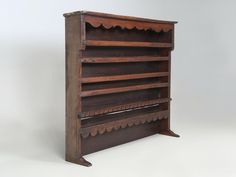 an old wooden book shelf with three shelves on each side and scalloped edges