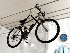 a bicycle hanging from the ceiling in a garage