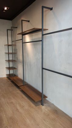 an empty room with shelving and shelves on the wall next to wood flooring