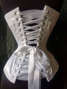 Quality construction and top end materials make my beautiful hand crafted corsets second to none. Designed to embrace your curves perfectly this heirloom corset will be the perfect romantic traditional piece for your wedding trousseau Please supply Full bust and cup size Waist at smallest Hip at widest Allow 4-6 weeks until shipping Formal Underbust Corset With Fitted Bodice, Elegant Underbust Corset With Satin Finish, Formal Overbust Corset With Boning, Wedding Underbust Corset Dress With Lined Bodice, Elegant Satin Finish Underbust Corset, White Overbust Corset Dress With Corset Back, Wedding Corset Dress With Satin Finish, White Overbust Corset Dress, Underbust Satin Corset With Satin Finish