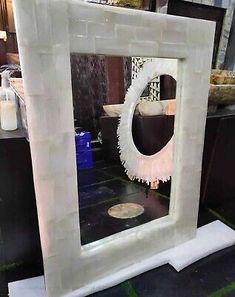 a white frame with a mirror on top of it in front of some other items