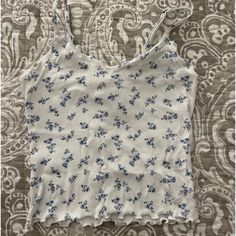 Never Worn Hollister Tank Top Blue And White Floral Design Lettuce Cut On The But Of Tank Top White Printed Cami Tops, Spring White Printed Tank Top, White Printed Tank Top For Spring, Printed Cotton Cami Top, Casual Blue Printed Tank Top, White Floral Print Cami Top, Casual White Floral Print Tank Top, White Casual Tank Top With Floral Print, Casual White Tank Top With Floral Print