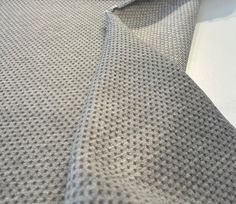 a close up view of a tie on a white tablecloth with a black and gray design