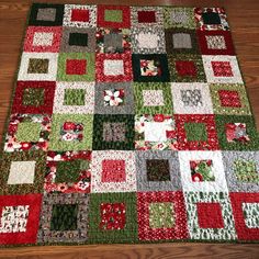 a patchwork quilt on the floor with red and green squares