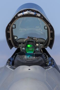 the cockpit compartment of an airplane with green light in it's window and door open