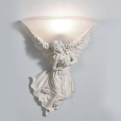 a white angel light fixture on the wall