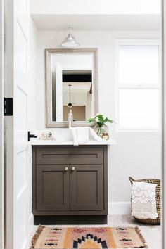 a bathroom with a rug, sink and mirror on the wall next to a door