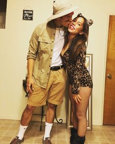 a man and woman posing for a photo in front of a door with their legs crossed