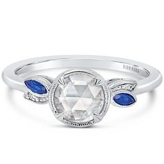 a white diamond and blue sapphire ring with an oval center stone in the center, surrounded by diamonds