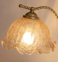 an old fashioned glass light hanging from a ceiling fixture with a rope attached to it