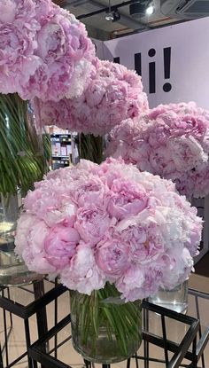 three vases filled with pink flowers on top of a table