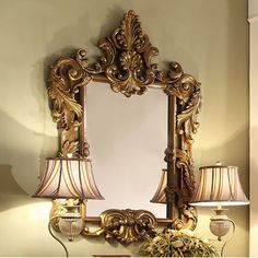 a mirror and two lamps on a table in front of a wall with a lamp