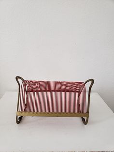 a red and white striped basket sitting on top of a table