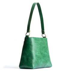 Effortless, Practical, Refined: our Triangle Shoulder Bag is perfect for everyday use. This handbag features a spacious interior and exterior pocket, comfortable shoulder strap and handy zipper.  Add an adjustable crossbody strap for a hands free option. Classic Baguette Bag With Adjustable Handle For Everyday Use, Green Baguette Bag With Removable Pouch For Everyday, Green Shoulder Bag With Adjustable Handle For Everyday Use, Everyday Crossbody Baguette Bag With Adjustable Handle, Everyday Green Shoulder Bag With Adjustable Handle, Green Baguette Bag With Detachable Strap For Everyday Use, Everyday Baguette Bag With Adjustable Handle, Leather Baguette Tote Bag With Adjustable Handle, Leather Hobo Shoulder Bag With Adjustable Handle