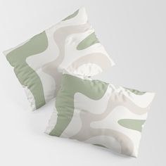 two green and white pillows sitting next to each other