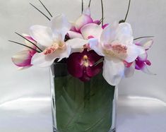 a glass vase filled with purple and white flowers