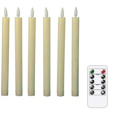 four candles with remote controls in front of white background, set of five lit up