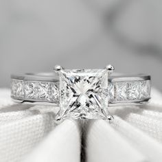 a princess cut diamond ring with channel set diamonds