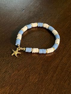 Blue and white bracelet with gold accents and a gold starfish Adjustable Blue Bracelets With Starfish Charm, Blue Bracelets With Starfish Charm Ocean-inspired, Blue Beaded Bracelet With Starfish Charm, Gold Ocean-inspired Starfish Bracelets, Ocean-inspired Blue Starfish Bracelets, Blue And Gold Bracelets, Casual Blue Beaded Bracelets With Starfish Charm, Casual Blue Jewelry With Starfish Charm, White Starfish Bracelet With Ocean-inspired Style