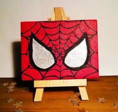 a spiderman painting on an easel with stars around it