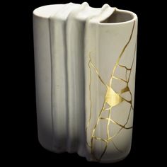 three white vases with gold designs on them