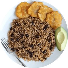 a white plate topped with rice and beans next to an avocado