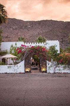 the entrance to an adobe style house with flowers growing on it