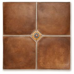 a brown square tile with an orange and blue flower in the center, on a white background