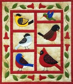 a quilted wall hanging with birds on it