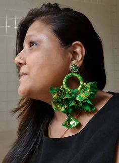 "Handmade emerald green and gold fabric oversized tassels and hoop earrings. These bright green and gold colored bold tassels earrings are made of polyester fabric with beaded post, genuinely beautiful and ideal for the spring summer. These fun earrings are very light in weight but look bold in size. The earrings weigh 17 gms a pair and fall approx. 5\" and 3.5\" wide At Carnation jewellery, each piece is handmade and handcrafted in India. There may be a slight imperfection due to the nature of Bohemian Green Earrings For Celebration, Green Latkan Earrings For Party, Festive Green Hoop Earrings, Green Dangle Hoop Earrings For Celebration, Green Earrings With Latkans For Party, Green Hoop Earrings For Party, Green Tassel Earrings As Gift, Green Bohemian Hoop Earrings For Festive Occasions, Handmade Green Hoop Earrings For Party