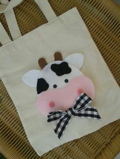 a paper bag with a cow on it and a bow around its neck is sitting on a wicker chair