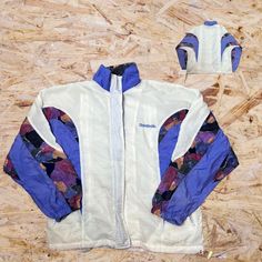 "Vintage Reebok Windbreaker Full Zip Jacket 90s Print White Purple Large Pit to pit 22\" Length 26\" Sleeve Length 20\" **Missing size tag** Please message us if you have any questions / need more photos or any measurements!!  Most of the items we sell are used and may contain flaws that have been overlooked while processing items. Please look through all the photos and description before purchasing.  Sold As Is!" Long Sleeve Streetwear Windbreaker With Moisture-wicking, Winter Drip, Retro Blue Long Sleeve Windbreaker, Vintage Purple Windbreaker For Streetwear, Blue Moisture-wicking Sportswear Windbreaker, Retro Blue Long-sleeve Windbreaker, Old Scool, Vintage Reebok, Ball Cap