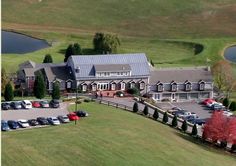 an aerial view of a large house with cars parked in the driveway and parking lot