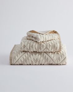 three towels stacked on top of each other in front of a white background with an embroidered design