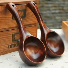 two wooden spoons sitting on top of a table next to a box and some boxes