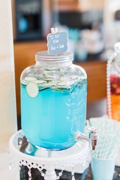 there is a blue drink in a jar on the table