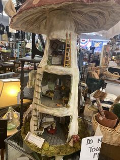 a mushroom like house is on display in a store with lots of other items around it