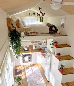 a small loft with stairs leading up to the bed area and kitchen in the background