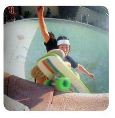 a man riding a skateboard up the side of a pool