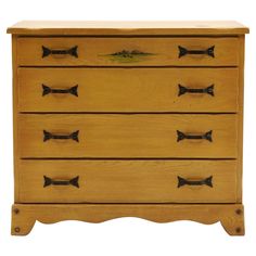 a wooden dresser with four drawers and three pulls on the front, one drawer has black handles