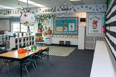 an empty classroom with desks, chairs and bookshelves in front of the door