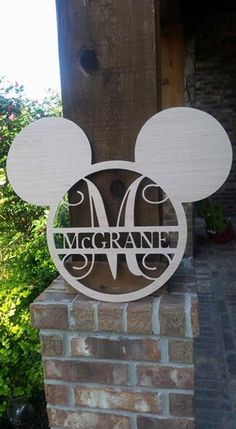 a mickey mouse head with the word'm'on it in front of a brick wall