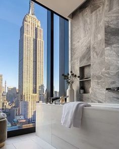 a bathroom with a large window overlooking the city