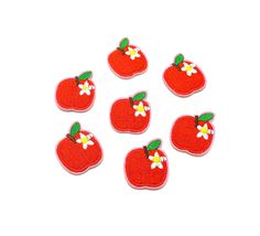 six red apple patches with white flowers on them