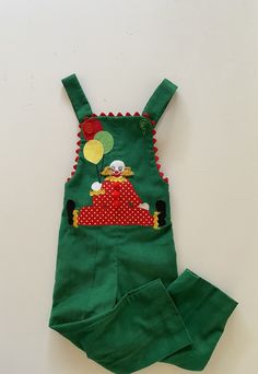 "Beautifully custom made new fun vintage toddler overalls.  Green pinwale corduroy.  Fun clown and balloons appliqued to the chest.  Red and green buttons, polka dot clown. These were custom made and have not been worn.  There is an additional 3 1/2\" on the straps to lower the buttons if desired to gain extra length. label:  Jilly's Unique Childrens Wear fabric:  feels like cotton corduroy size:  Size 4/5 is just an estimate.  Please check measurements for an accurate fit.  Questions are welcome! overalls were measured across the front side lying flat waist 10 1/2\" stretches to 12\" rise 20\" inseam 13 1/2\" total length 33\" leg hem 6\"" Fun Cotton Overalls For Playtime, Vintage Cotton Overalls For Playtime, Toddler Overalls, Corduroy Overalls, Kids Overalls, Vintage Toddler, Ric Rac, Red Polka Dot, Vintage Children