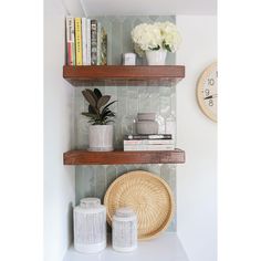 a shelf with books, vases and other items on it next to a clock