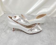 a pair of white high heels with crystal embellishments