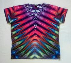 a colorful tie - dyed shirt is displayed on a white surface